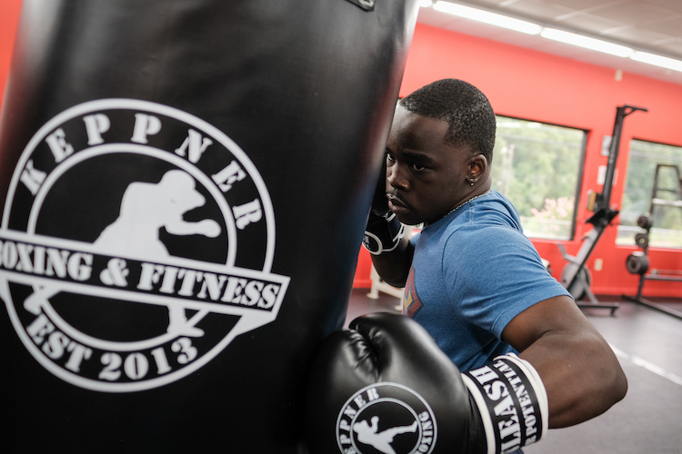 guy punching heavy bag in personal training session